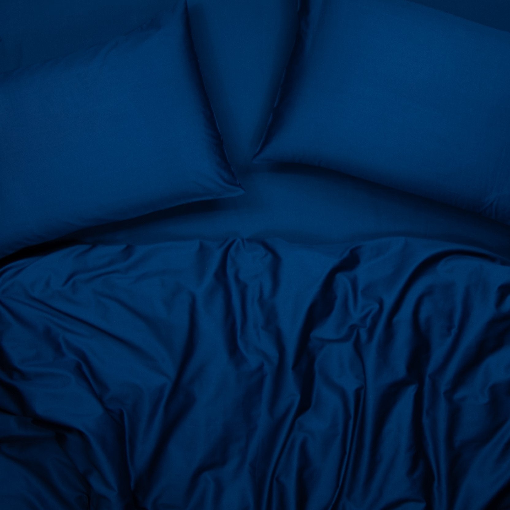 Birds eye view of organic cotton quilt cover set with pillowcases and quilt cover in classic blue