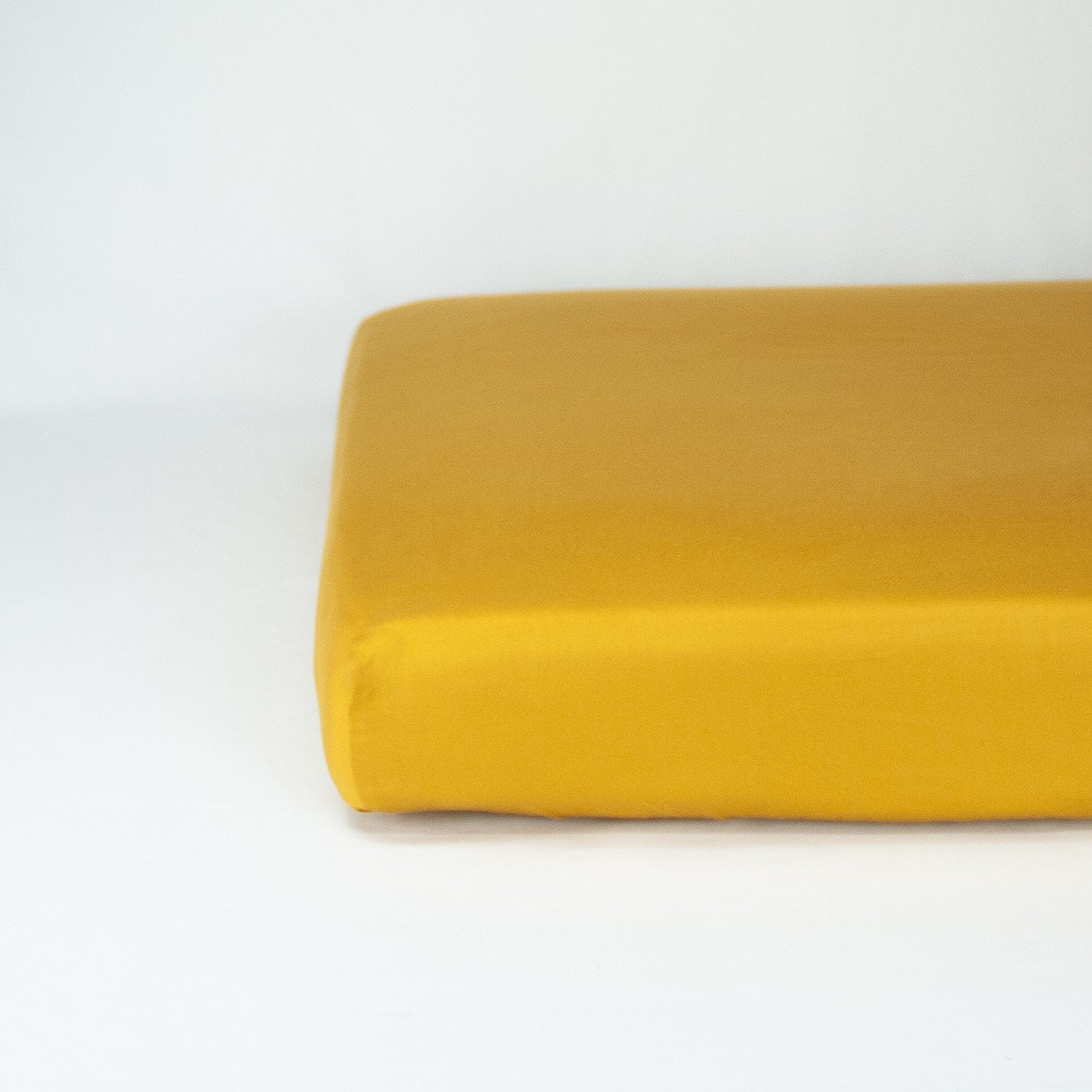 End of mattress with organic cotton fitted cot sheet in honey gold
