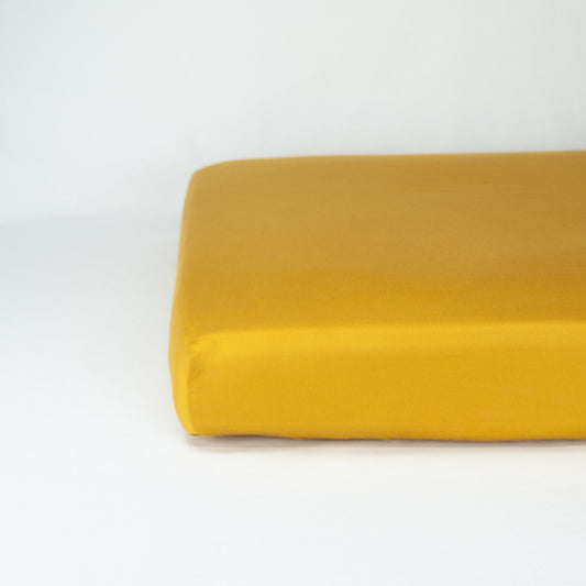 End of mattress with organic cotton fitted cot sheet in honey gold