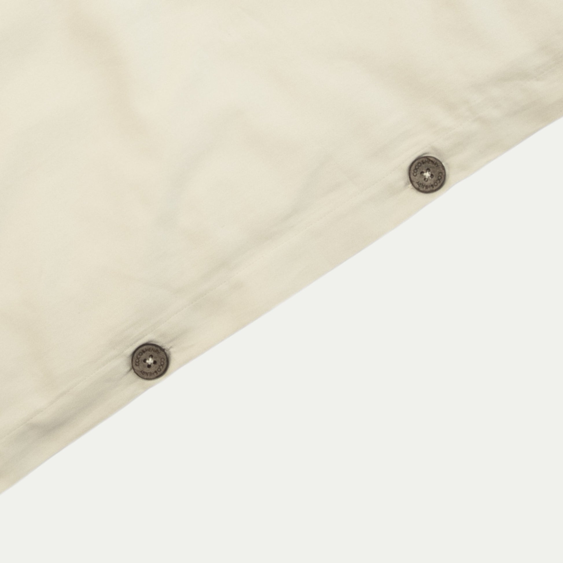 Close up of quilt cover edge with coconut buttons in egg shell white