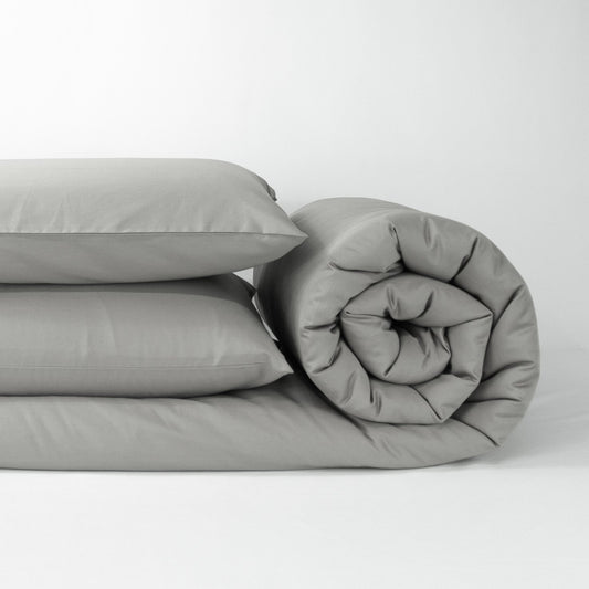 Stack of organic cotton quilt cover set with pillowcases and rolled up quilt cover in sleet grey