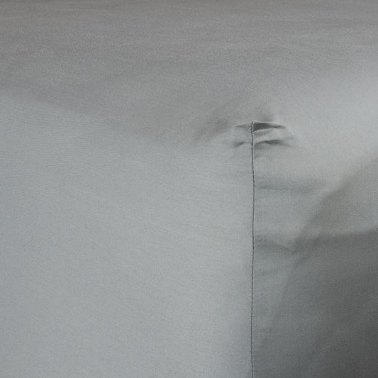 Corner of bed with organic cotton fitted sheet in sleet grey