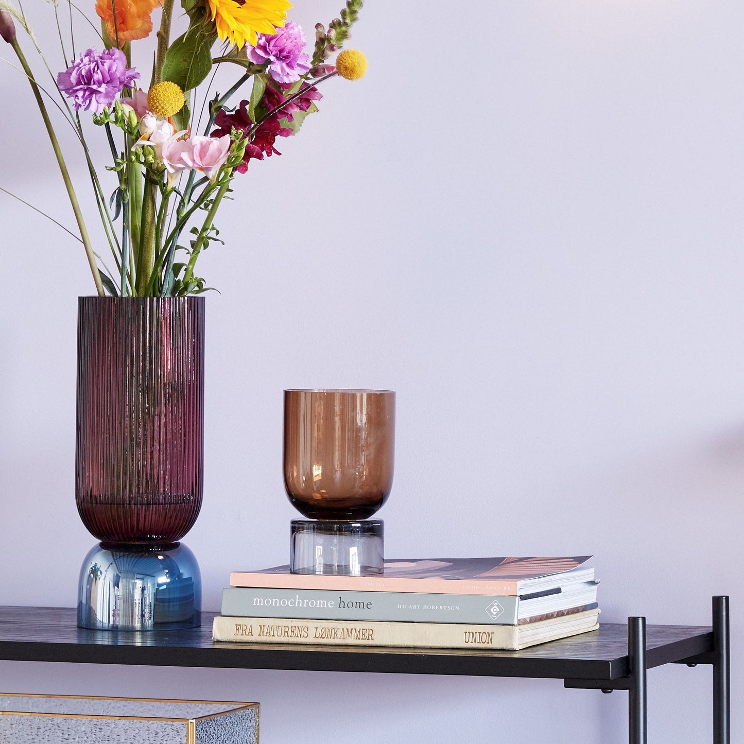 Hubsch Interior Nordic designer art deco hour glass vase in pink and blue glass on a bookshelf with books