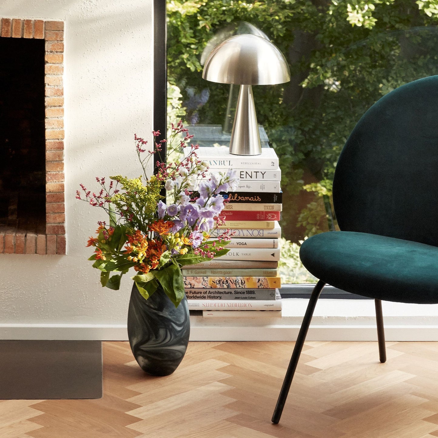Hubsch Interior Scandi style marbled floor vase in white and dark green glass with flower arrangement next to green chair