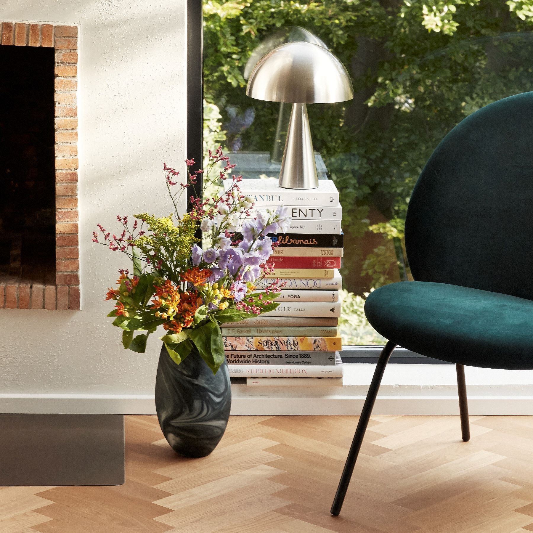 Hubsch Interior Scandi style marbled floor vase in white and dark green glass with flower arrangement next to green chair