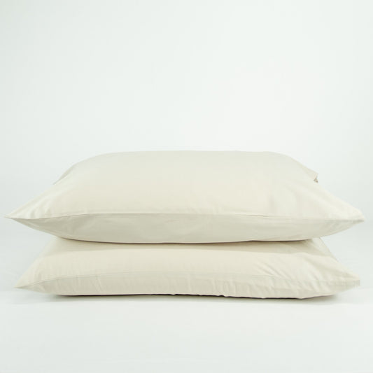 Stacked organic cotton pillowcases in egg shell white