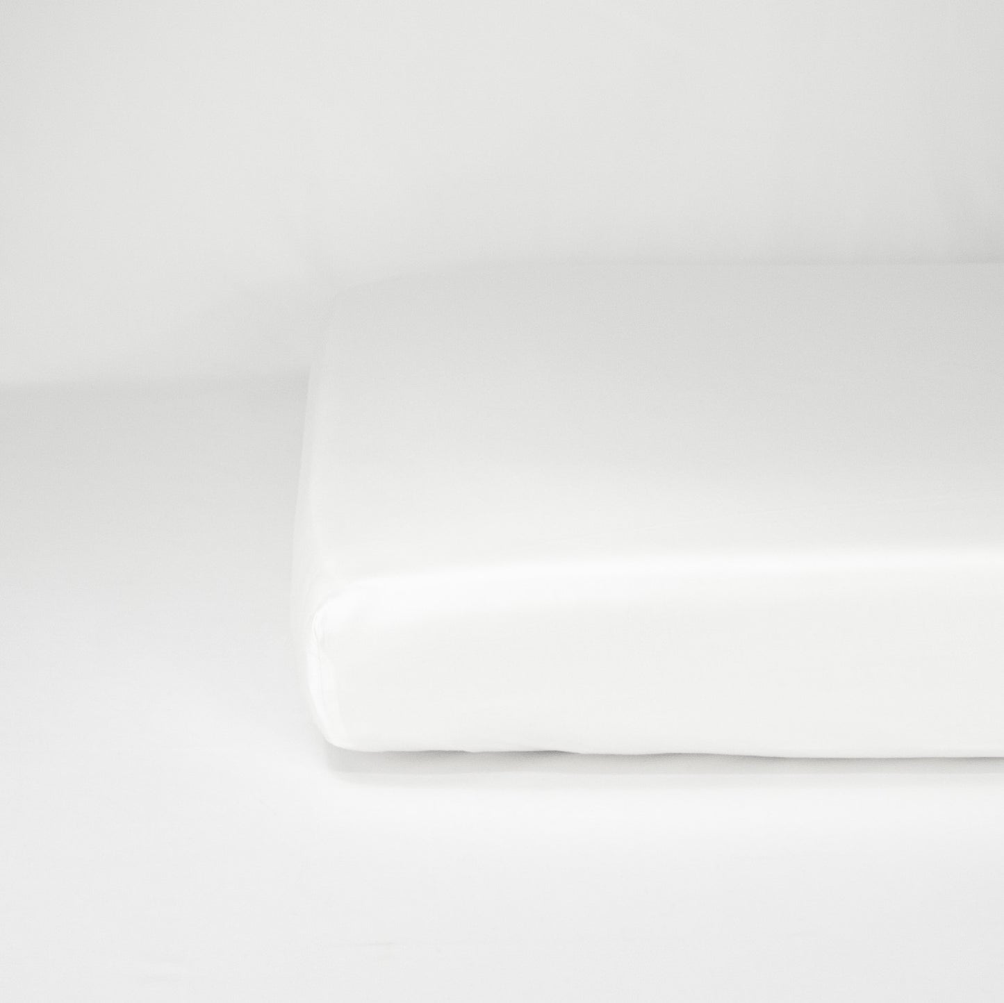 End of mattress with organic cotton fitted cot sheet in pure white