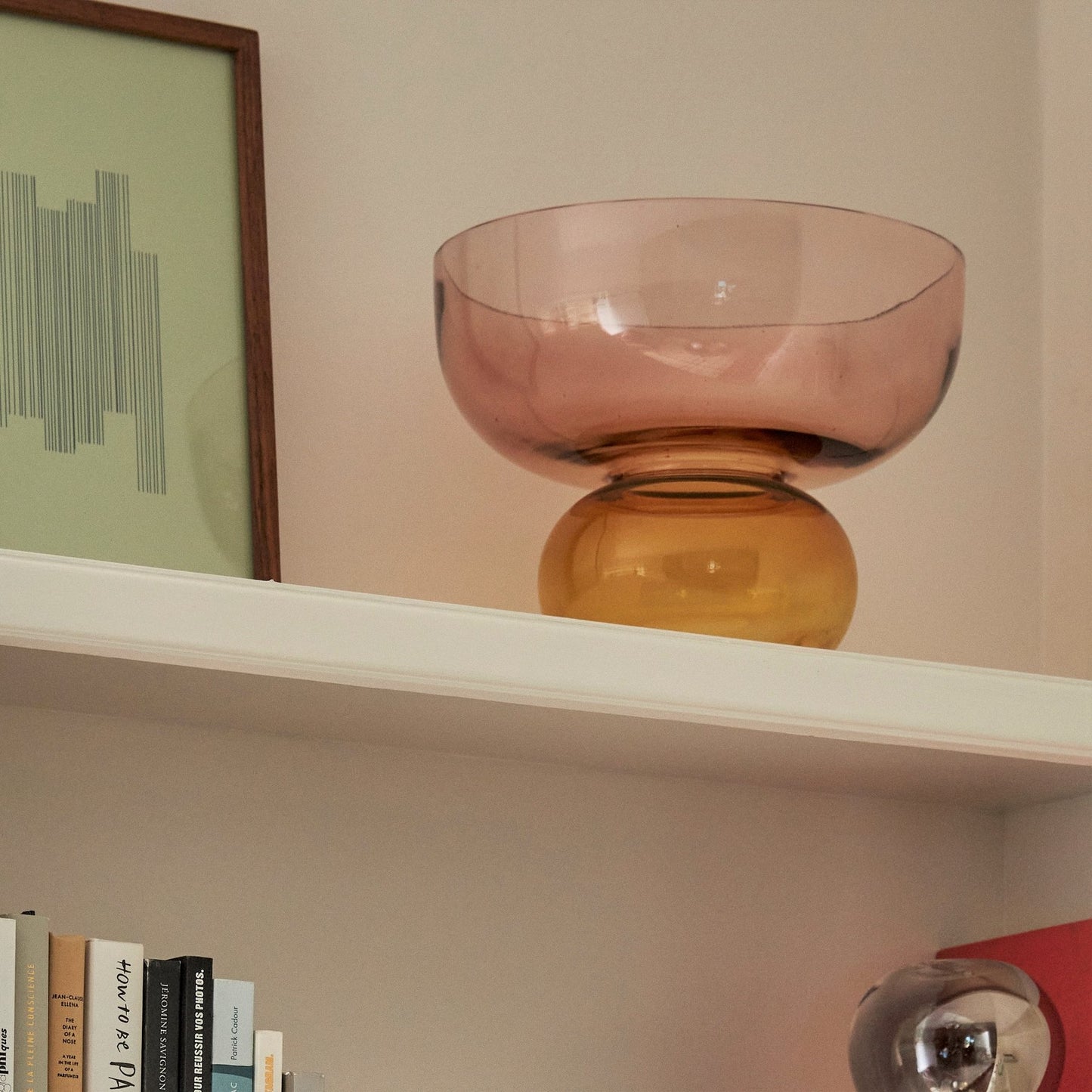Hubsch Interior Nordic designer round bowl vase in pink and orange amber glass with orchid plant inside on shelf