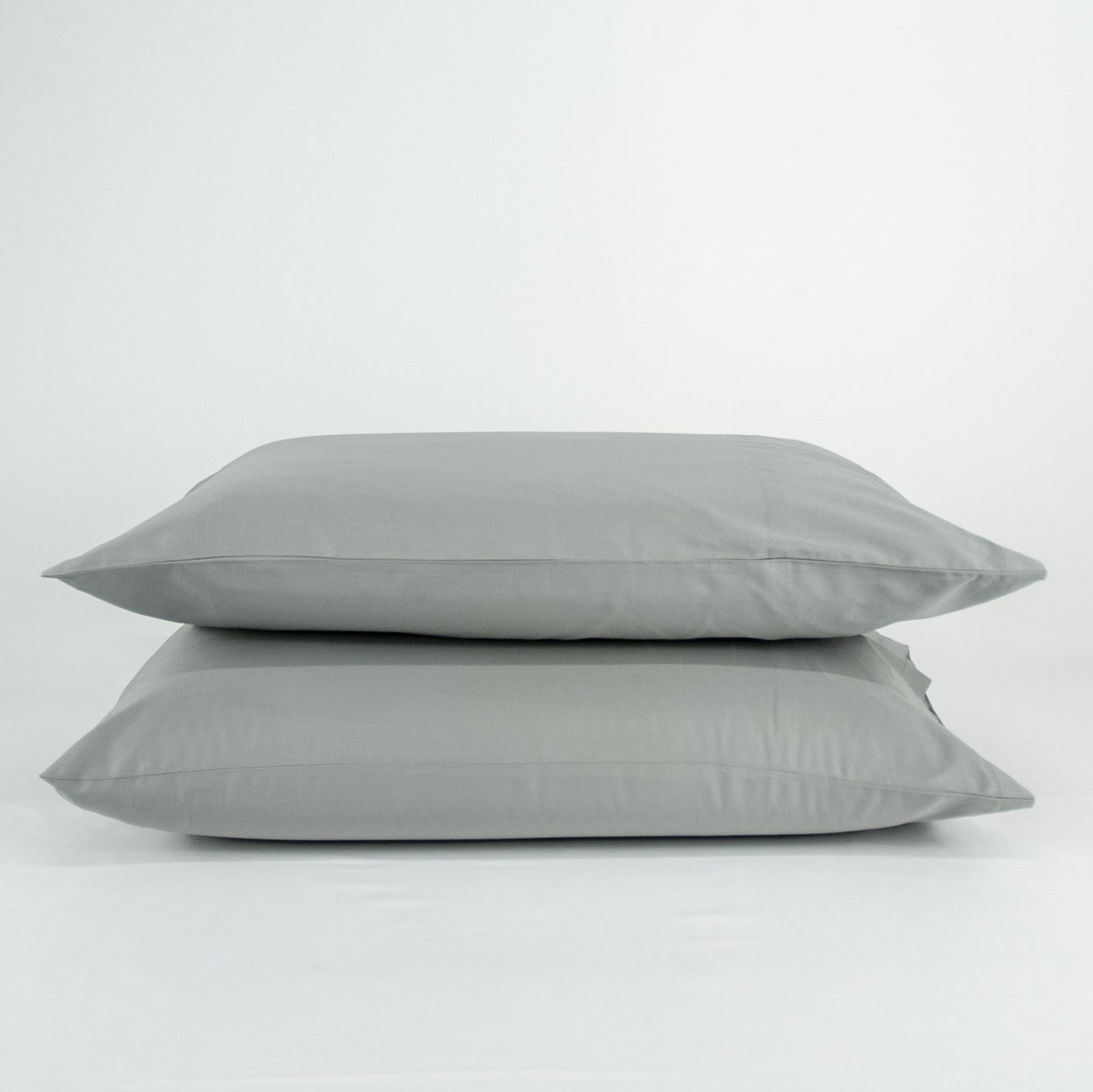 Stacked organic cotton pillowcases in sleet grey
