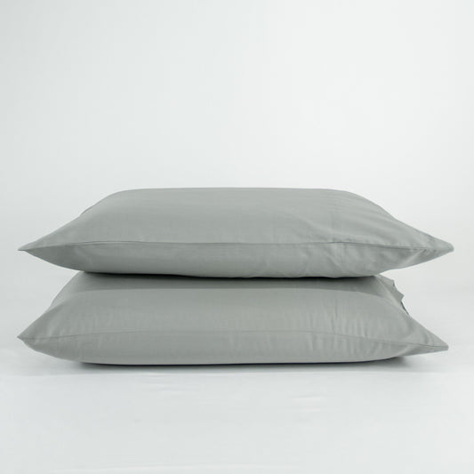 Stacked organic cotton pillowcases in sleet grey